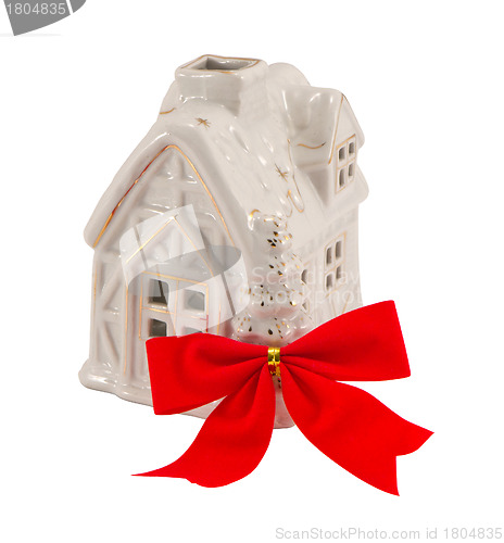 Image of Small white house and red band ribbon. Christmas present. 