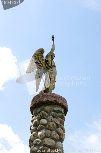 Image of Angel hold torch on stone platform sky background 