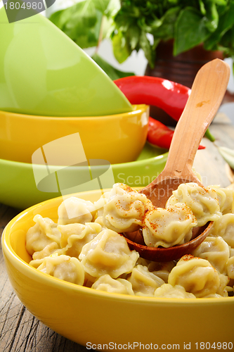 Image of Dumplings in a bowl and wooden spoon.