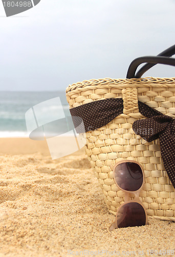 Image of Seacoast, straw beach bag and sunglasses 	