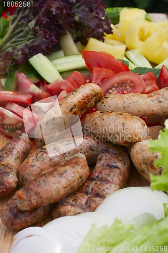 Image of grilled sausage, fresh herbs, tomatoes, onions