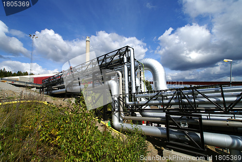 Image of industrial pipelines and smokestack with a natural blue backgrou