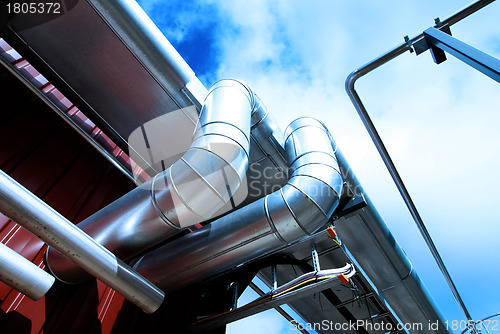 Image of industrial pipelines and valve with a natural blue background