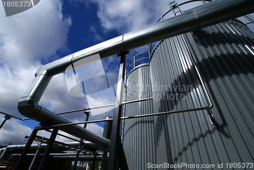 Image of industrial pipelines and tanks with a natural blue background