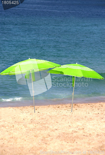 Image of Two green sun umbrellas on the beach 