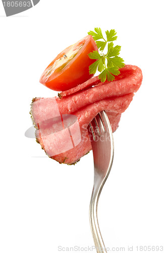 Image of fork with sausage and tomato