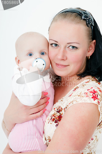 Image of baby with a pacifier in the arms of mother