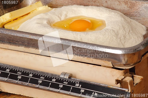 Image of Kitchen scales with egg butter and flour