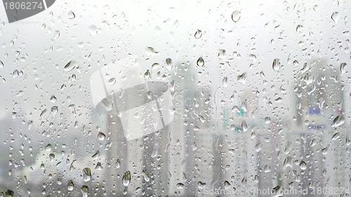 Image of rain drops on glass with city background