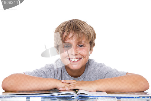 Image of Smiling boy with  book on the table 