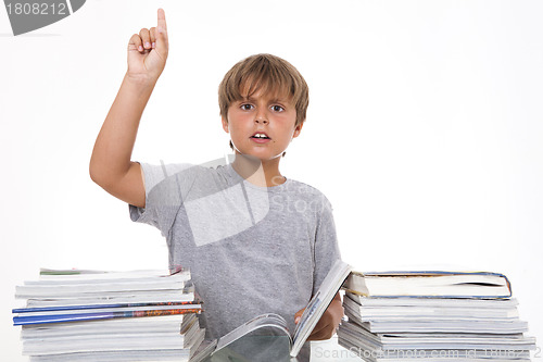 Image of Smiling boy with books on the desk showing attention