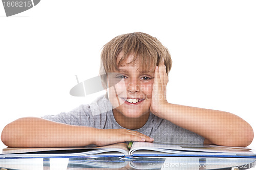 Image of Smiling boy with  book on the table