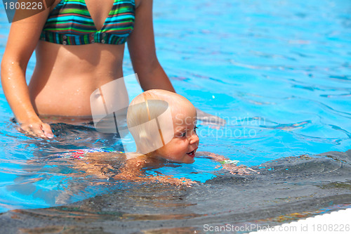 Image of Child having fun in water with mom.