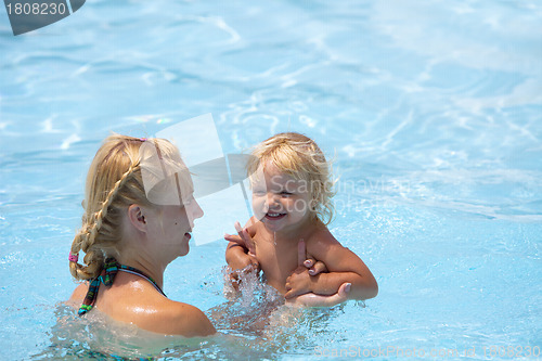 Image of Child having fun in water with mom.