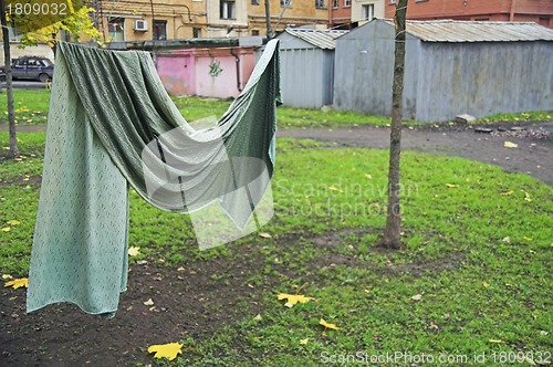 Image of Curtain drying on string in backyard