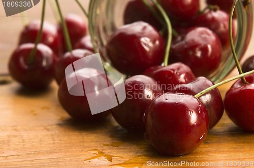Image of Cherry in glass jar isolated on the wooden background