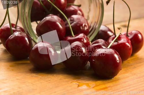 Image of Cherry in glass jar isolated on the wooden background