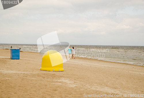 Image of Recycling waste bins on sea coast and people walk 