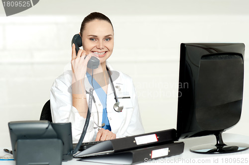 Image of Beautiful nurse talking on phone with patient