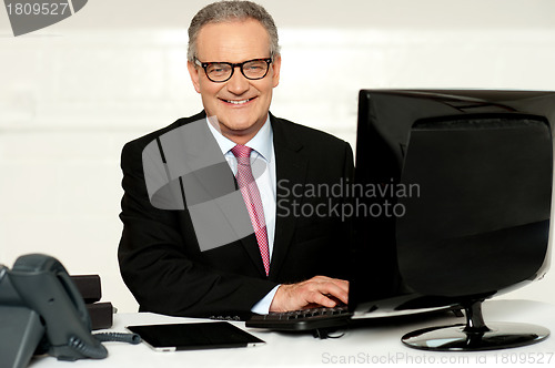 Image of Happy aged corporate man typing on keyboard
