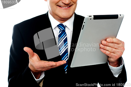 Image of Cropped image of a businessman holding tablet pc