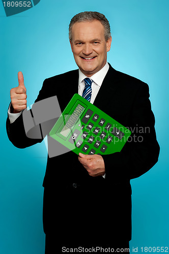 Image of Businessman showing thumbs up, holding calculator