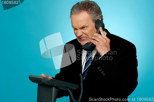Image of Irritated businessman communicating on phone