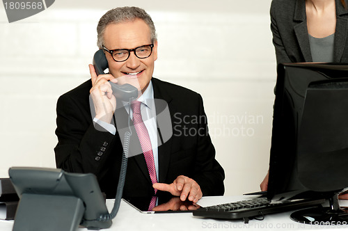 Image of Aged businessman communicating on phone