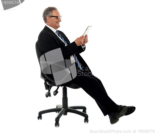 Image of Well dressed corporate male holding wireless tablet