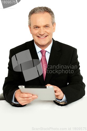 Image of Handsome aged business male using tablet pc