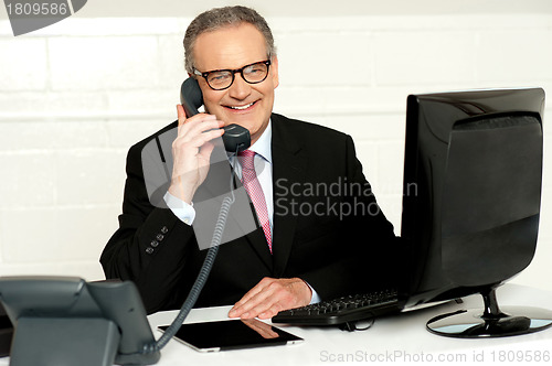 Image of Senior businessman attending phone call