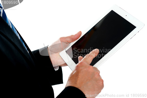 Image of Man operating touch screen device, focus on tablet