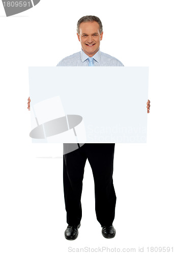 Image of Confident businessman holding blank billboard