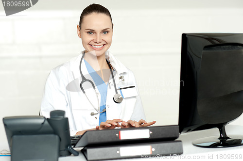 Image of Cheerful female doctor tying on keyboard