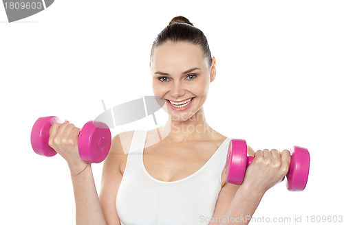 Image of Attractive athlete exercising with dumbbells