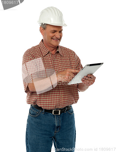 Image of Aged architect using tablet pc