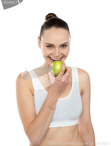 Image of Healthy fit woman eating fresh green apple