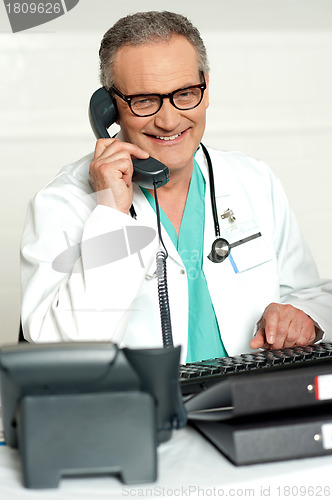 Image of Matured physician communicating on phone