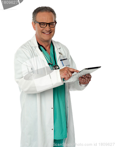 Image of Cheerful doctor using wireless tablet device