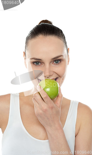 Image of Closeup portrait of beautiful woman eating green apple