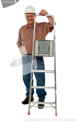 Image of Smiling construction worker holding ladder