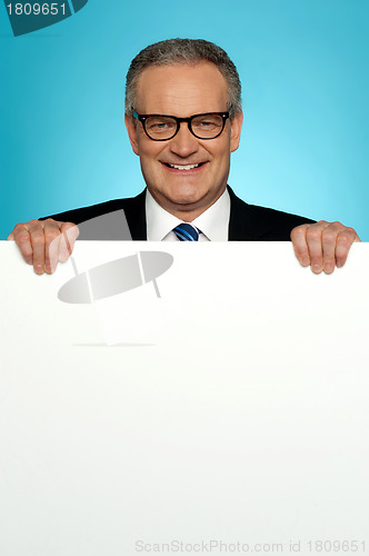 Image of Corporate man standing behind big blank billboard