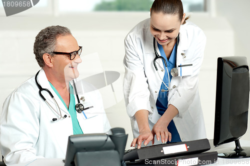 Image of Smiling medical team working on computer