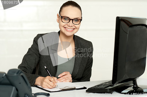 Image of Female executive writing on notepad