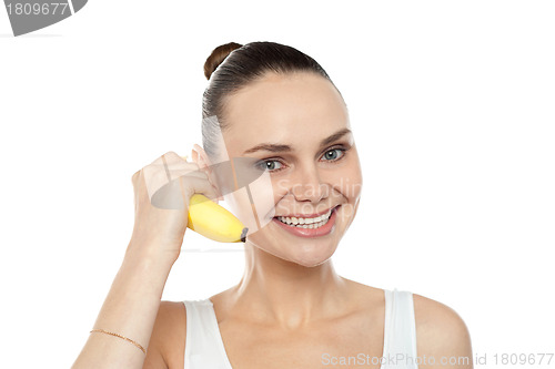 Image of Girl doing call gesture using banana as cellphone