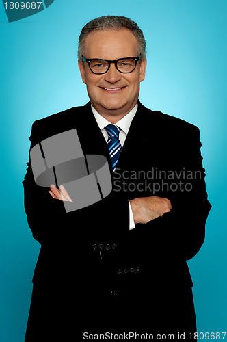 Image of Smiling businessman posing with crossed arms