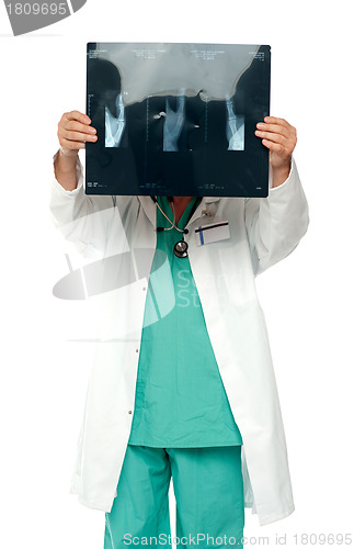 Image of Male surgeon hiding his face with x-ray report