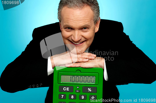 Image of Aged corporate male resting face on big calculator