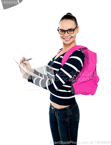 Image of Trendy college girl taking down notes