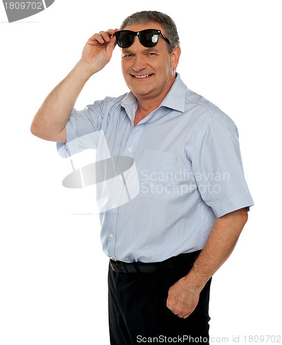 Image of Casual man holding sunglasses over his head